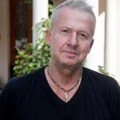 Bogusław Linda, ikona polskich filmów, w czarnej koszulce i z naszyjnikiem.