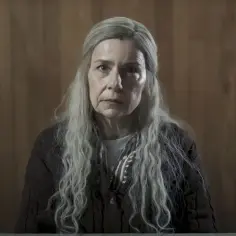 Agata Kulesza w roli tajemniczej postaci z długimi, siwymi włosami. Jej twarz wyraża powagę, sugerując głęboką historię z seriali i programów.