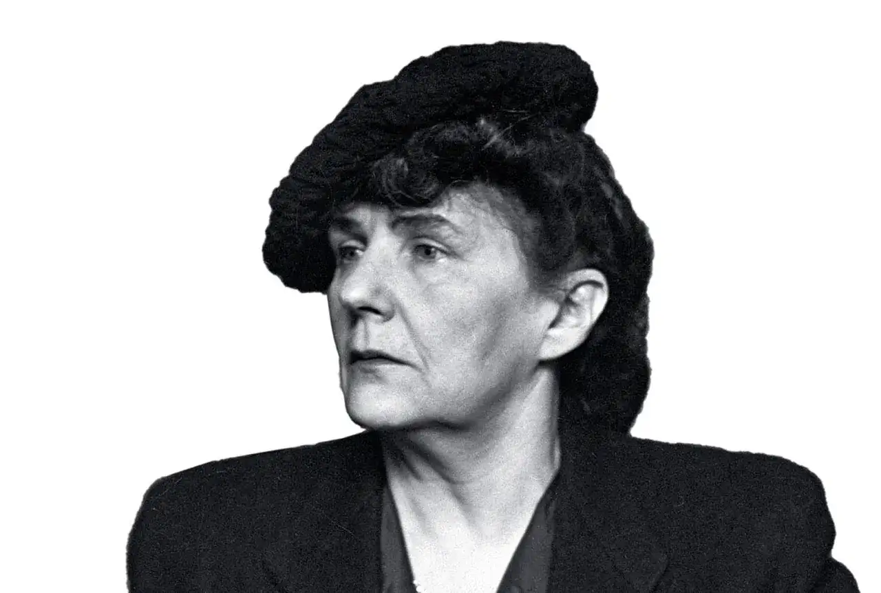 Portret kobiety w stylowej czapce, zamyślonej, jakby szukała słów do kolejnego dzieła. Ta literatka ma w sobie siłę.